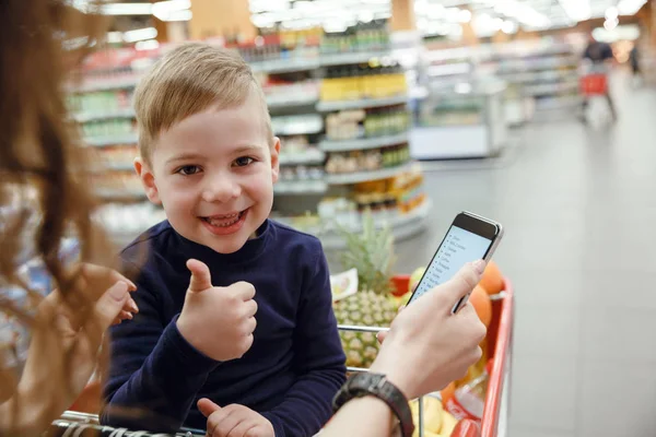 Счастливый ребенок, показывающий большой палец в торговом центре — стоковое фото