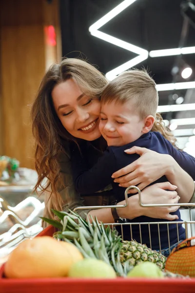 Imagem vertical da mulher com criança no supermercado — Fotografia de Stock