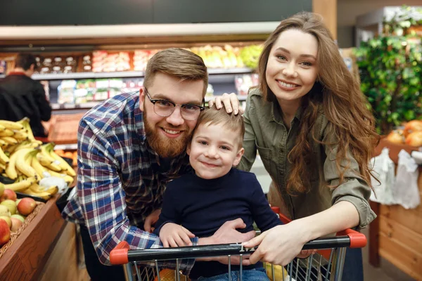 Счастливая семья позирует в супермаркете — стоковое фото