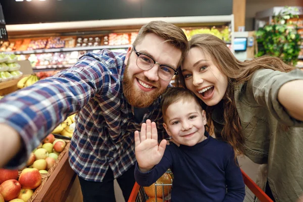 Feliz jovem família posando no supermercado — Fotografia de Stock