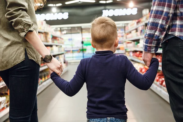 Rückansicht eines Jungen, der mit seinen Eltern spazieren geht — Stockfoto