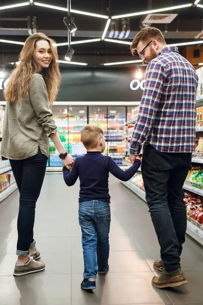 Immagine verticale di una giovane famiglia che cammina e gioca in supermarke — Foto Stock