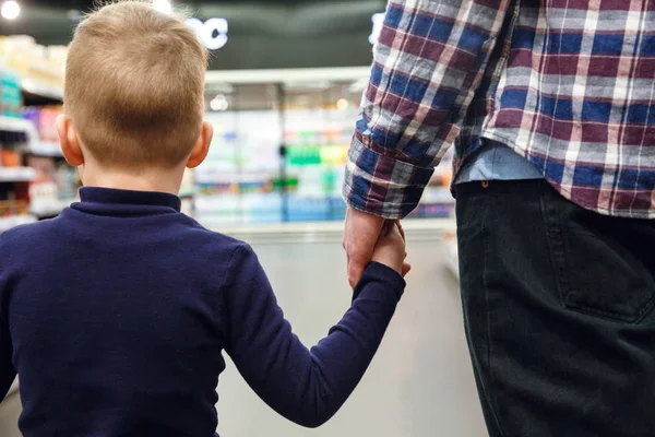 Imagen recortada de Hijo caminando con padre en supermercado — Foto de Stock