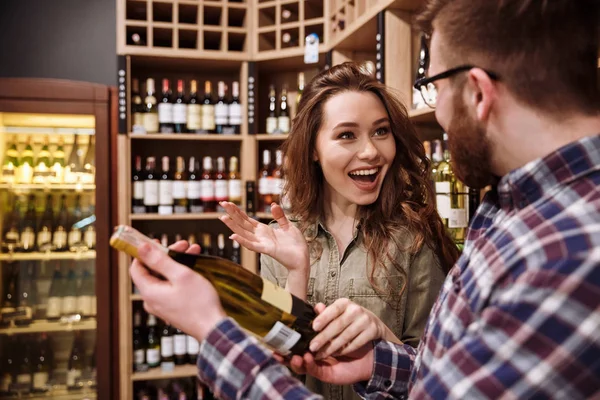 Gelukkige paar fles wijn kiezen — Stockfoto