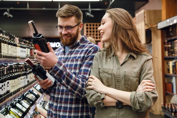 Jong koppel fles wijn kiezen — Stockfoto