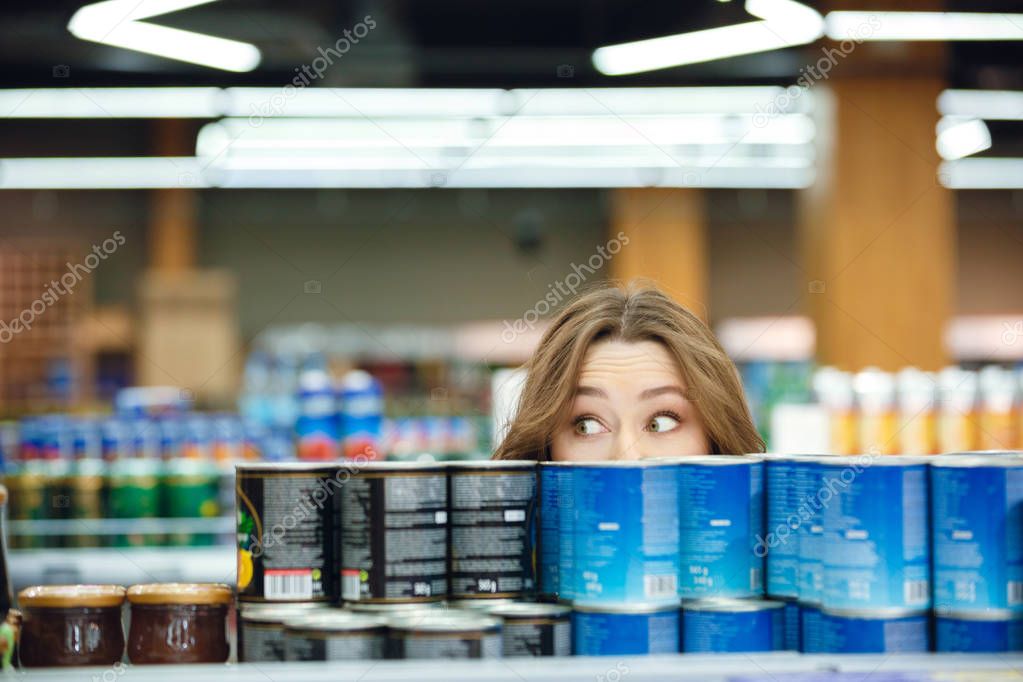 Young casual woman picking groceries in a supermarket