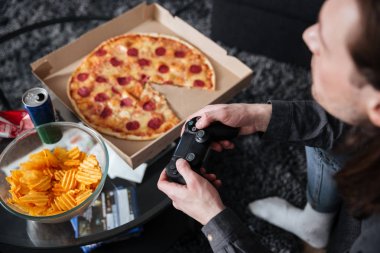 Adam oyun oyun oyunlar joystick pizza ve patates cipsi ile.