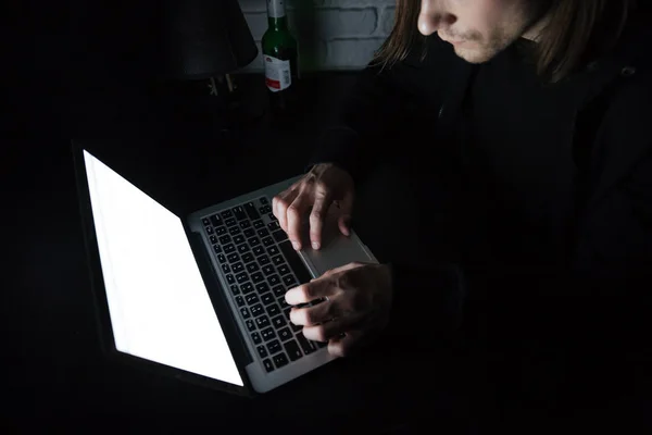 Молодой серьезный мужчина использует ноутбук дома — стоковое фото
