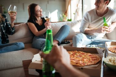 Pizza, şarap ve bira konuşan ve gülen grubu