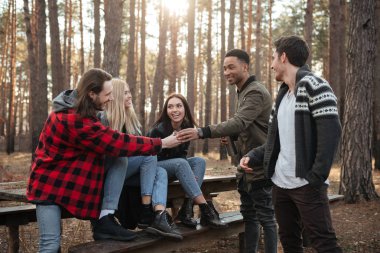 Açık havada ormanda oturan arkadaşlar mutlu grup