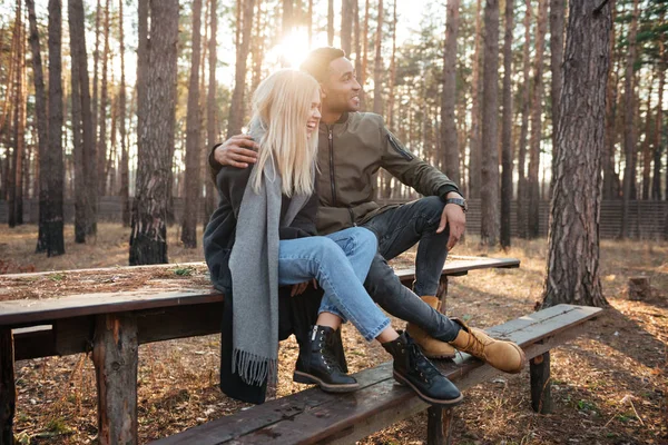 Veselém milující pár sedí venku v lese — Stock fotografie