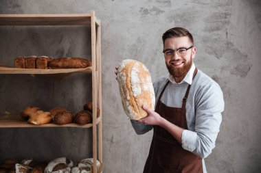 Fırında ekmek holding ayakta neşeli genç adam baker