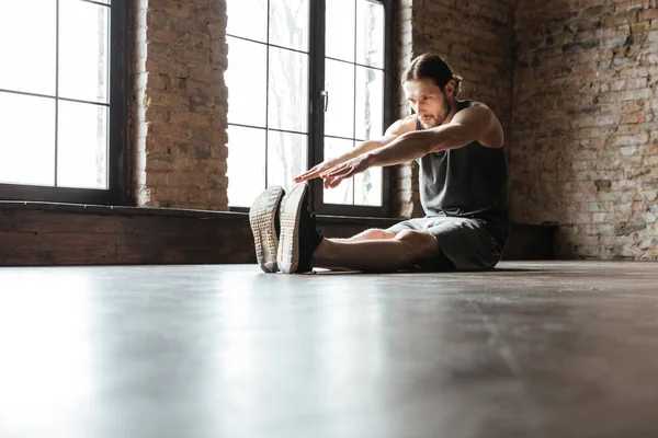 Portrait of a healthy sportsman doing stretching exercises — Stock Photo, Image