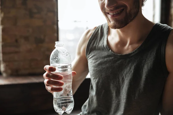 Vágott egy mosolygó fitness ember gazdaság a vizes palackot képe — Stock Fotó
