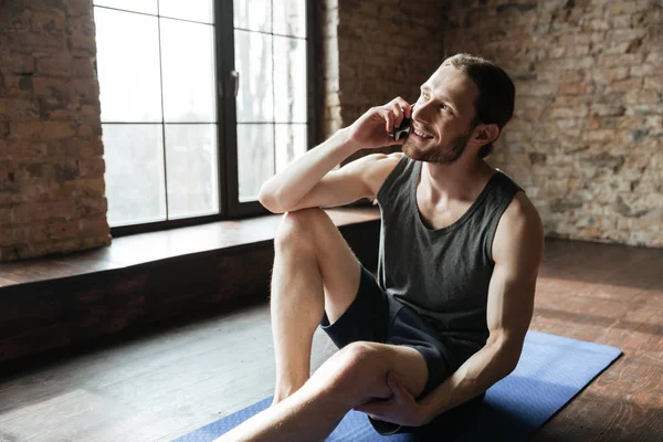 Портрет счастливого здорового спортсмена, разговаривающего по мобильному телефону — стоковое фото