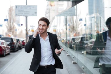 İş Merkezi yakınlarındaki telefonla konuşurken neşeli genç işadamı