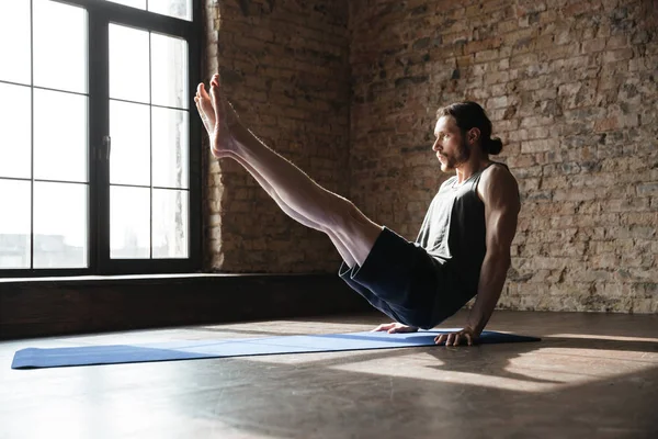 Сконцентрированный сильный спортсмен в тренажерном зале делает упражнения для йоги — стоковое фото