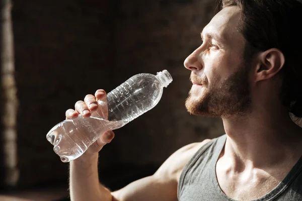 Stark sportsman i gym dricksvatten. — Stockfoto