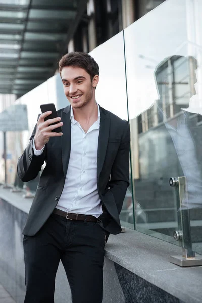 Happy young businessman walking near business center. — Stock Photo, Image