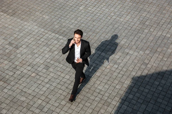 Jovem empresário feliz andando ao ar livre — Fotografia de Stock