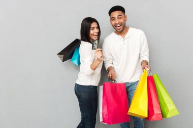 Mutlu sevgi dolu çift holding alışveriş torbaları ve kredi kartı