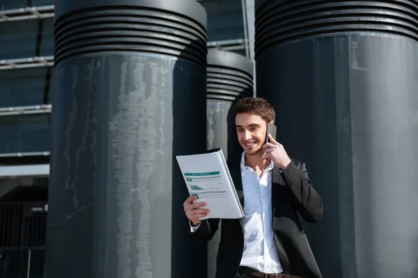 Hombre ocupado sosteniendo documentos y hablando por teléfono — Foto de Stock