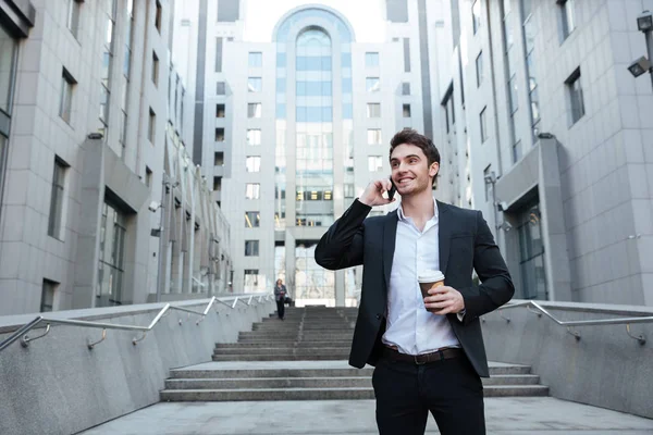 Empresario sosteniendo café y teléfono — Foto de Stock