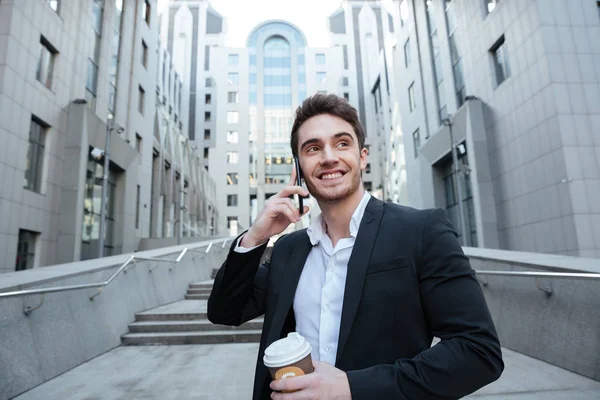 Empresario sosteniendo café y teléfono — Foto de Stock