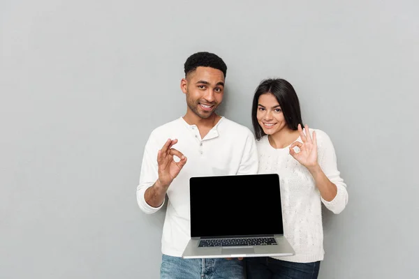 Alegre pareja amorosa que muestra la pantalla de la computadora portátil — Foto de Stock