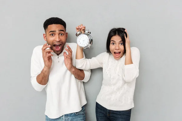 Gritando casal amoroso confuso mostrando alarme . — Fotografia de Stock