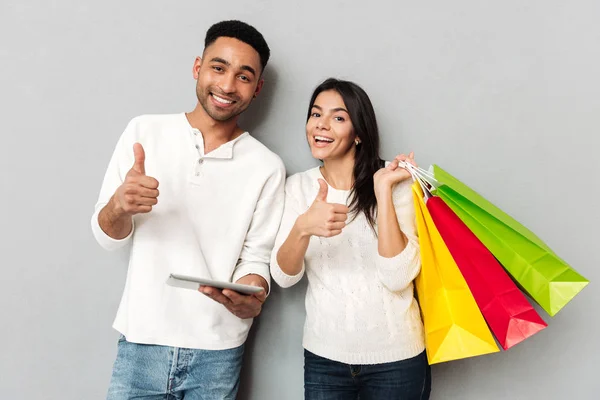 Casal feliz com tablet e pacotes isolados — Fotografia de Stock