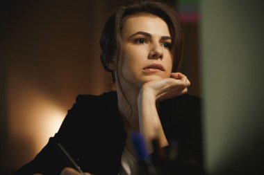 Geceleri ofisinde oturan ciddi genç bayan Tasarımcısı