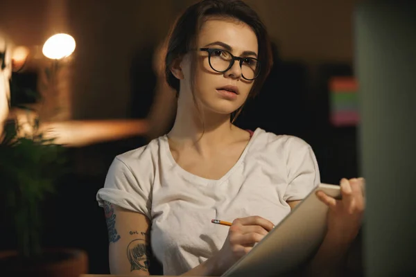 Concentrated young lady designer writing notes using computer — Stock Photo, Image