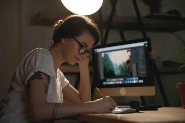 Lady designer sitting indoors at night drawing sketches — Stock Photo, Image