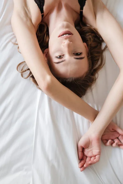 非常にセクシーなブルネットの女性がベッドの上にあります。 — ストック写真