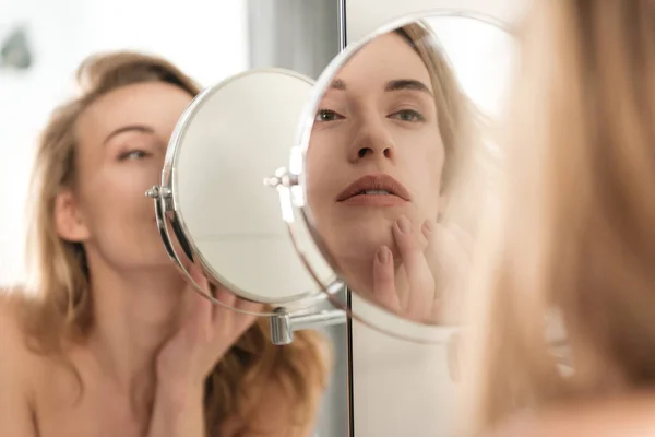 Hermosa joven mujer desnuda mirando al espejo . — Foto de Stock