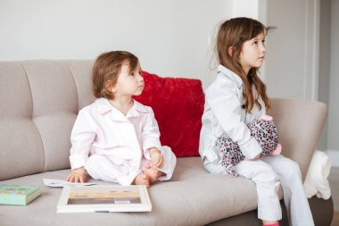 İki küçük kız kanepede oturan