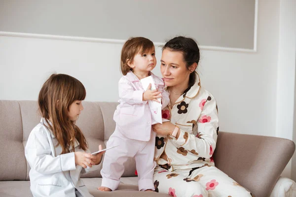 Mutter sitzt neben ihren Kindern — Stockfoto