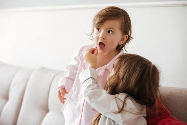 Kakak perempuan makan dengan popcorn muda — Stok Foto