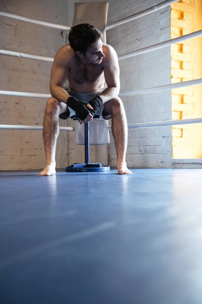 Fiatal bokszoló ül a sarokban a boksz ring — Stock Fotó
