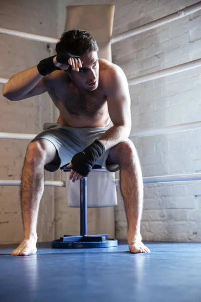 Fáradt boxer letörölte az izzadságot ülve, a gyűrű — Stock Fotó