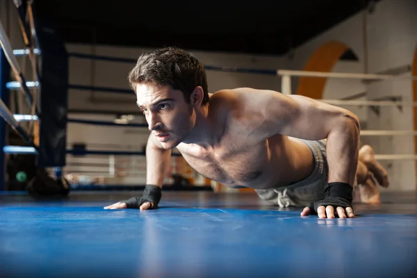 Боковой вид сильного боксера, делающего отжимания — стоковое фото