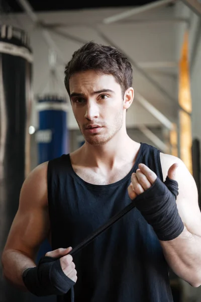 Fuerte deportista serio mirando hacia otro lado mientras entrena — Foto de Stock