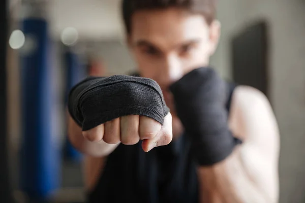 Vista de cerca del joven boxeador haciendo ejercicio en el gimnasio —  Fotos de Stock