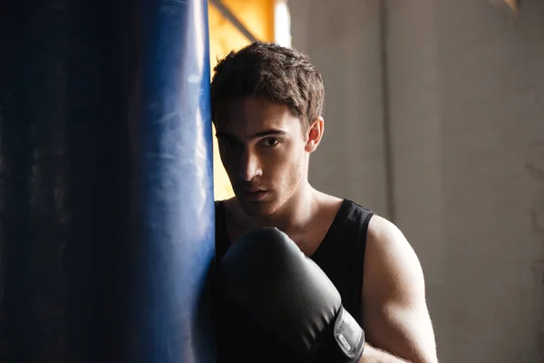 Portrét boxer poblíž jako boxovací pytel ve stínu — Stock fotografie