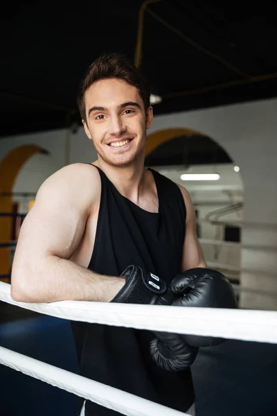 Hombre boxeador mirando cámara mientras está de pie en el anillo — Foto de Stock