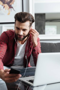 Kanepede oturan telefon kullanan ciddi adam