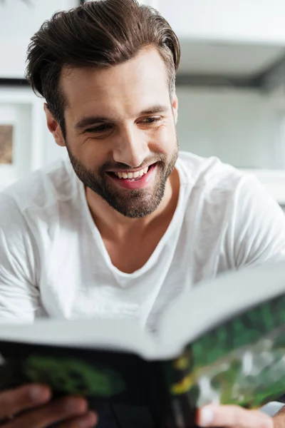 Hombre sonriente leyendo libro. Mirando a un lado . — Foto de Stock