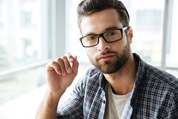 Bello uomo con gli occhiali seduto in ufficio coworking — Foto Stock