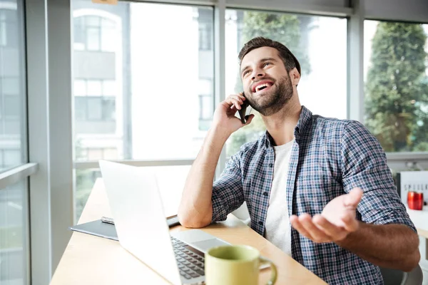 Munter mann på kontoret snakker per telefon – stockfoto